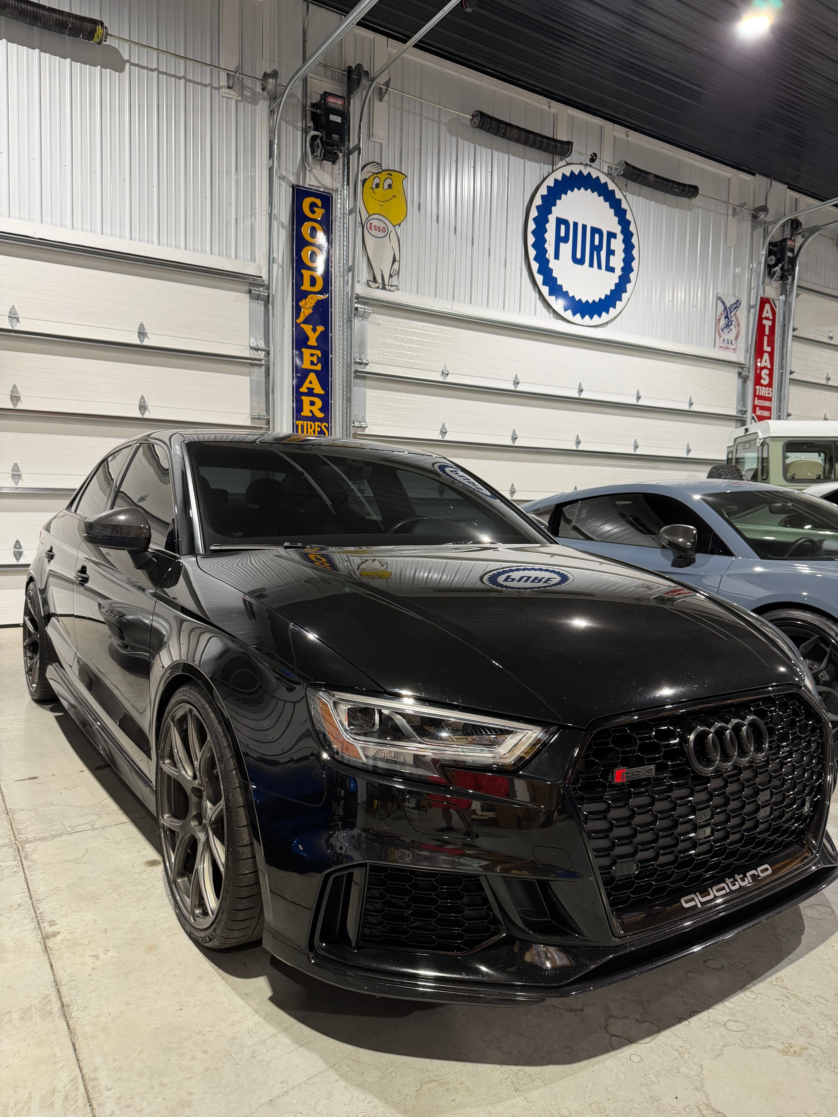 2019 Audi RS3 Mythos Black — front three-quarter view in shop